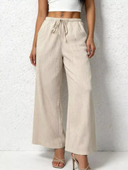 Relaxed beige cotton wide-leg pants with adjustable drawstring waist and pockets.
