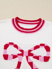 White sweater with red and pink checkered bow graphic and striped neckline.