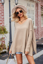 Tan acrylic v-neck sweater with asymmetric hemline and ribbed sleeves.