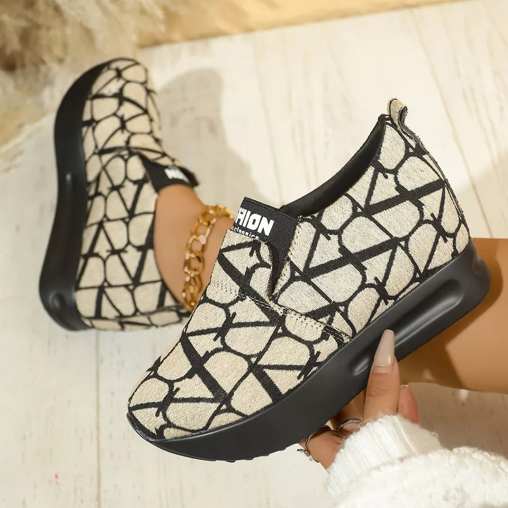 Beige and black geometric patterned slip-on sneakers with a platform sole.