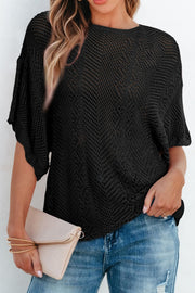 Black open-knit chevron sleeve top with a relaxed fit, styled with jeans and a clutch.