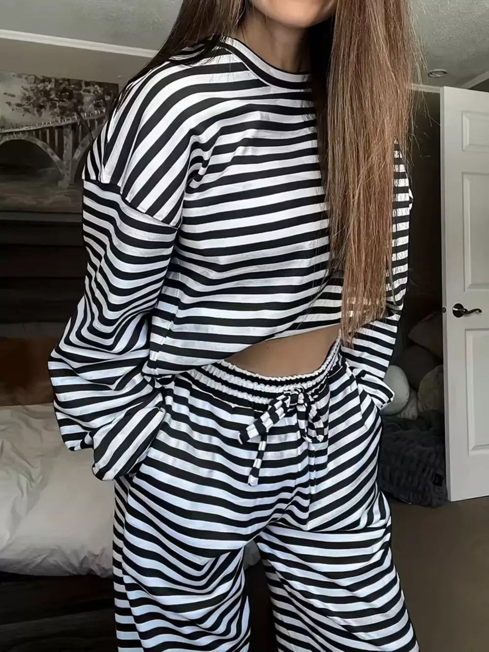 Black and white striped pajama set with drawstring waist pants and long sleeve top.