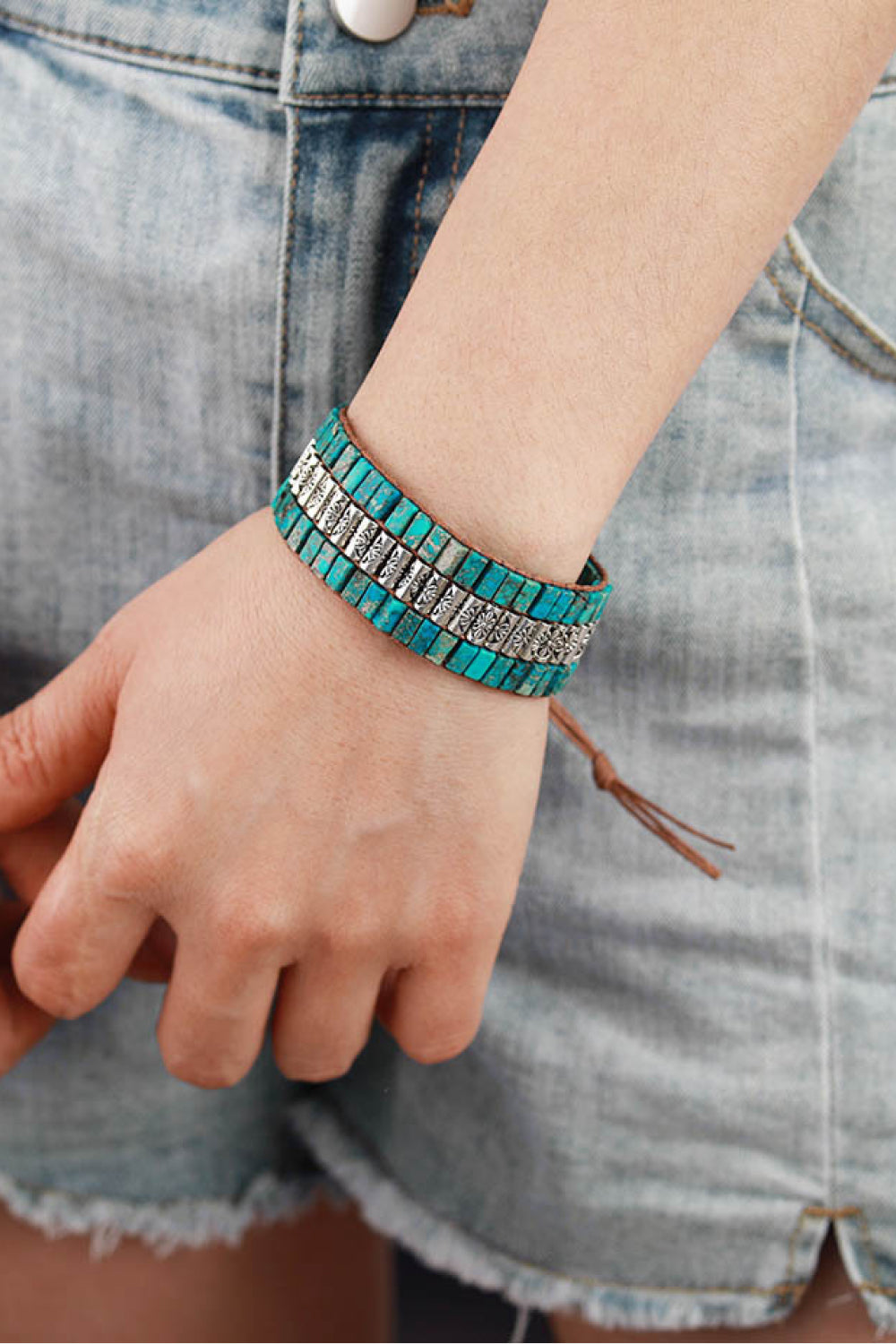 Turquoise tile and floral accent bracelet with leather cord and tie closure.