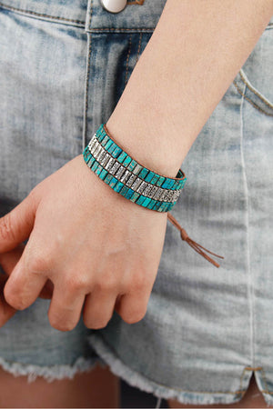 Turquoise tile and floral accent bracelet with leather cord and tie closure.