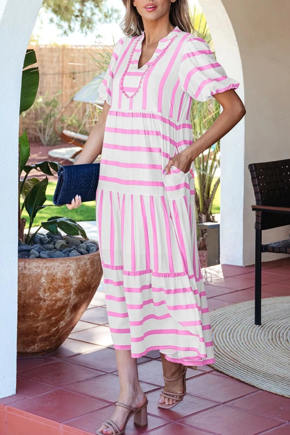 Maxi dress with pink stripes, notched neck, short sleeves, tiered skirt, and pockets.