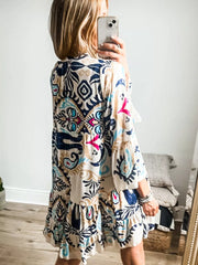 Vibrant tiered mini dress with abstract print, button detail, and bell sleeves.