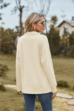 Ivory textured cable knit polo top with long sleeves and a collared neckline.