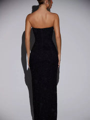 Black strapless maxi dress with textured fabric and a dramatic split.