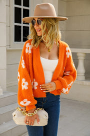 Orange fuzzy cropped cardigan with white floral pattern, open front, long sleeves