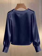 Dark blue satin blouse with round neck and long puff sleeves with cuffs.