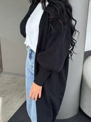 Black acrylic maxi cardigan with balloon sleeves and ribbed cuffs.
