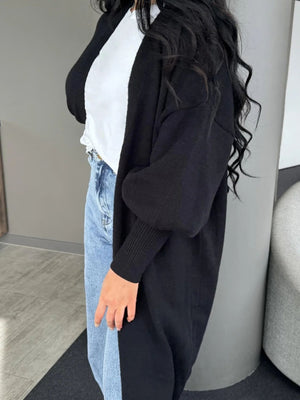 Black acrylic maxi cardigan with balloon sleeves and ribbed cuffs.