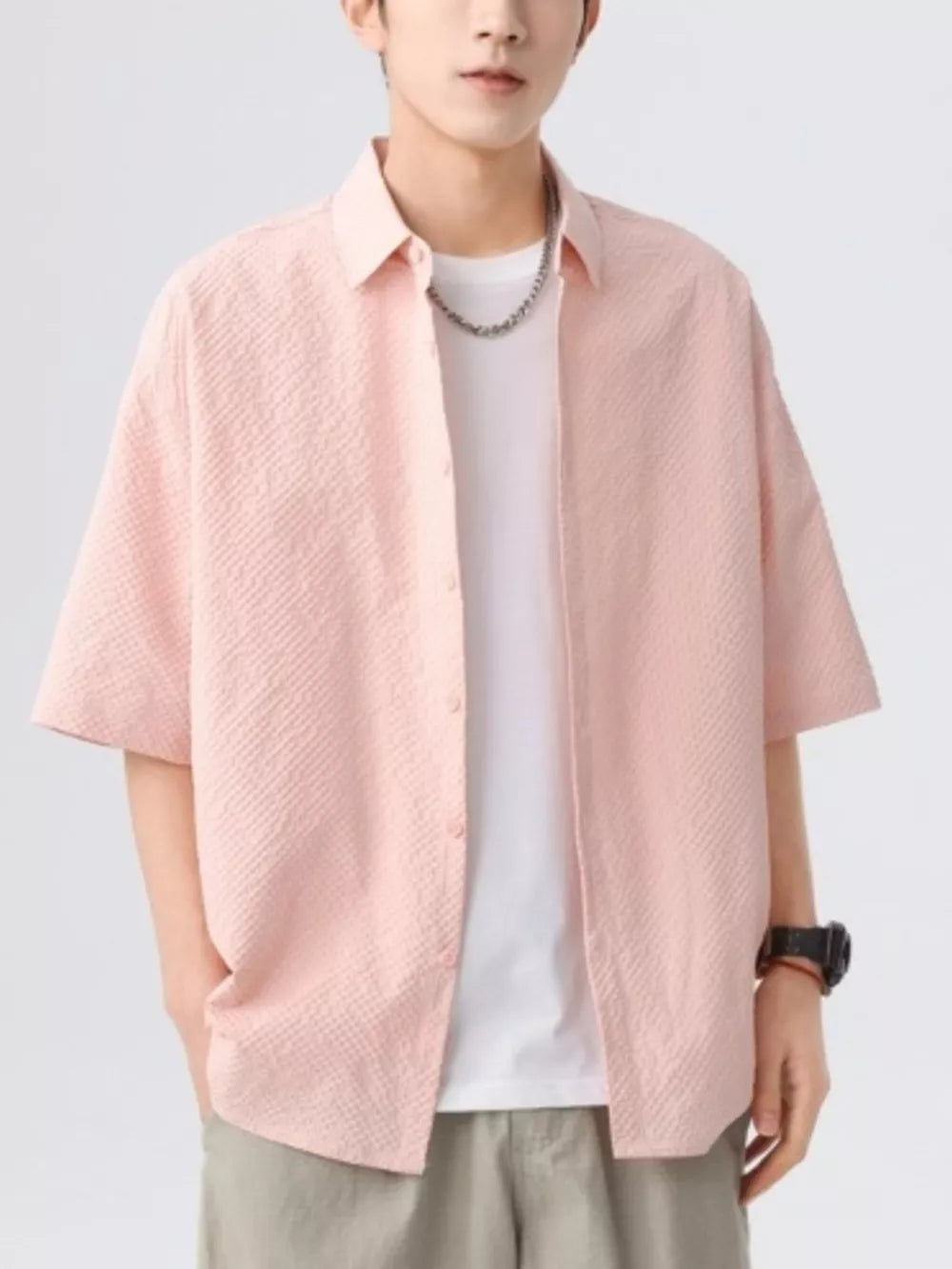 Pink textured short-sleeve men's shirt with button-up front and collar.