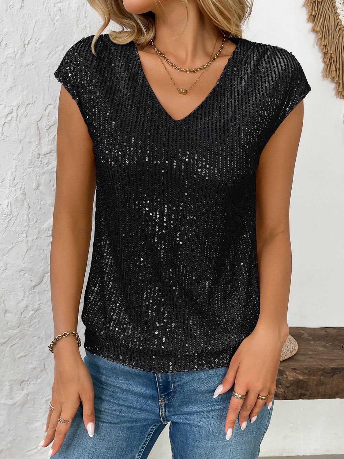 Black sequined cap-sleeve V-neck blouse with vertical stripe pattern.