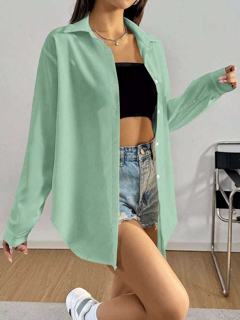 Gray green long sleeve button-up maternity shirt with classic collar, worn open over a black tube top and denim shorts.