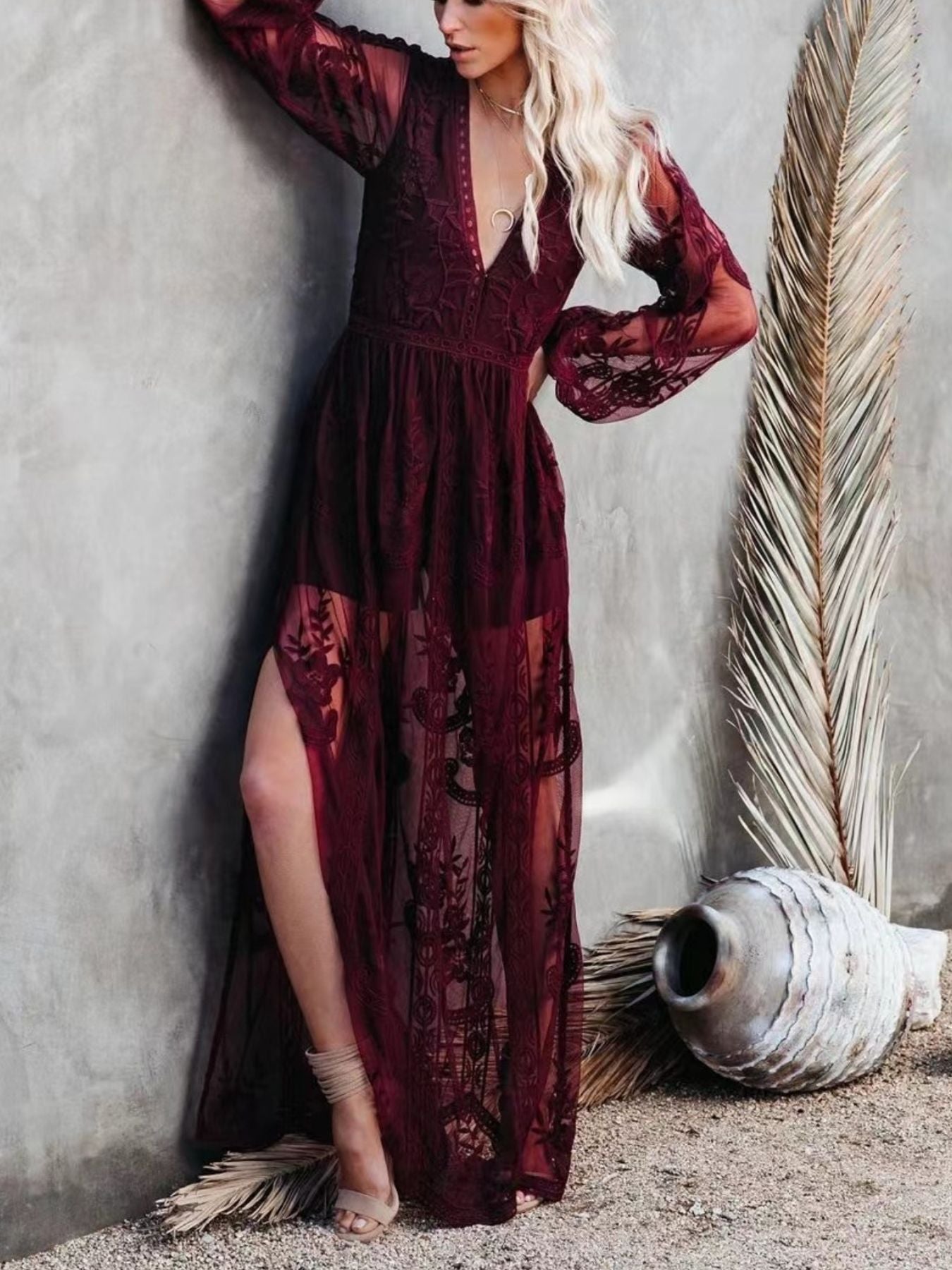 Burgundy floral lace maxi dress with plunging neckline, long bell sleeves, and high slit.