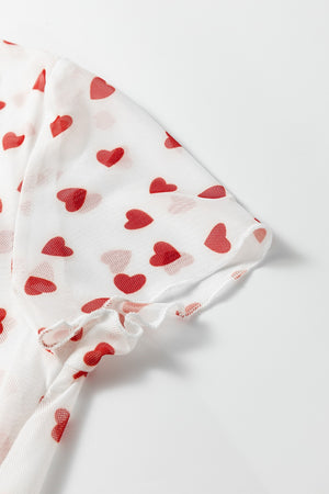 White mesh t-shirt with red heart print and ruffled sleeve hem.