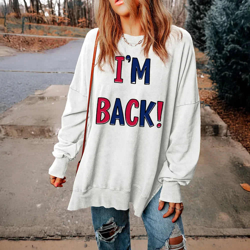 White graphic sweatshirt with I'M BACK! text, slit hem, and crew neck.
