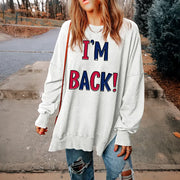 White graphic sweatshirt with I'M BACK! text, slit hem, and crew neck.