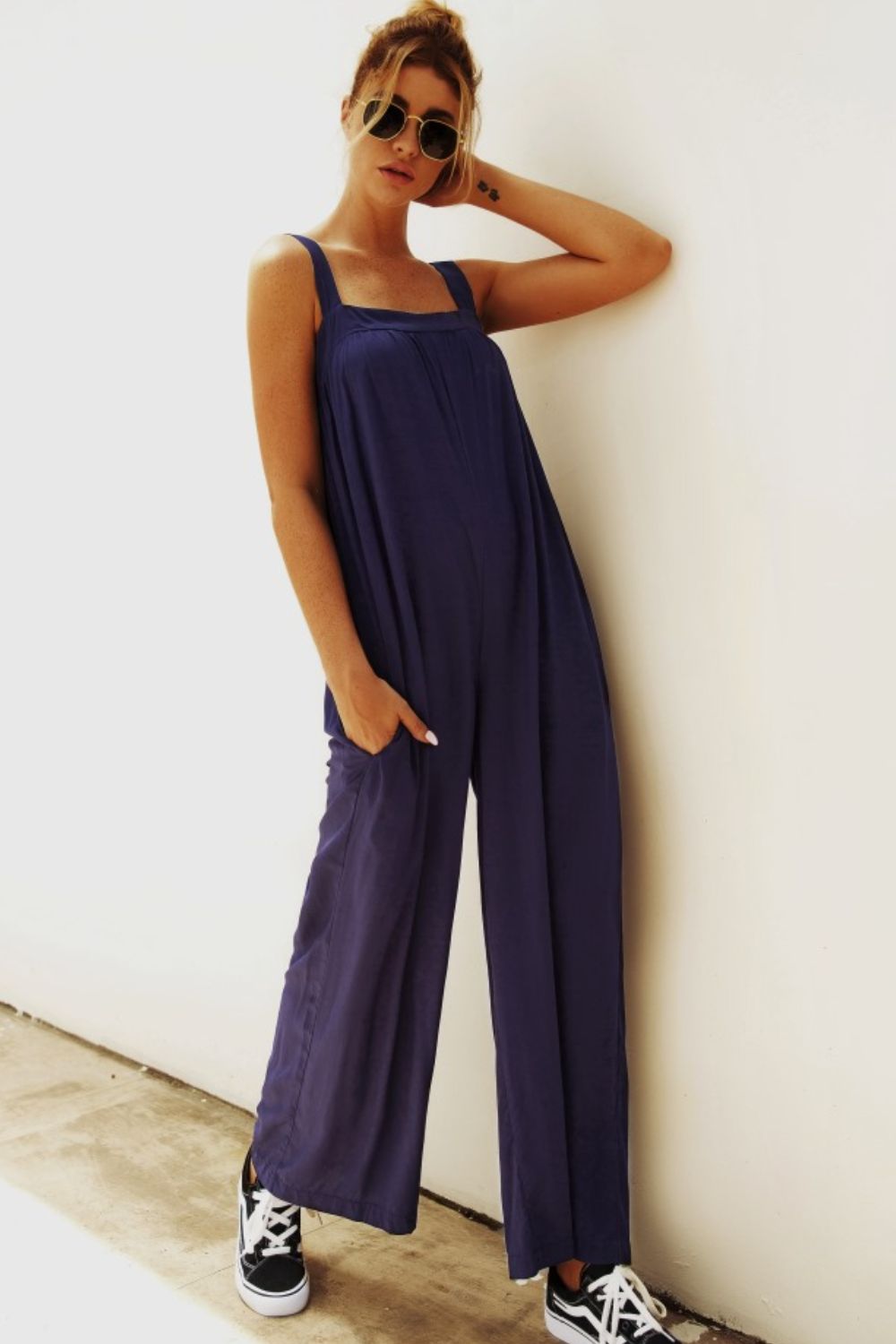 Dark blue square-neck palazzo jumpsuit with pockets and wide legs.