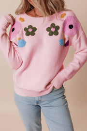 Blush pink knit sweater with embroidered floral appliqués and crewneck.