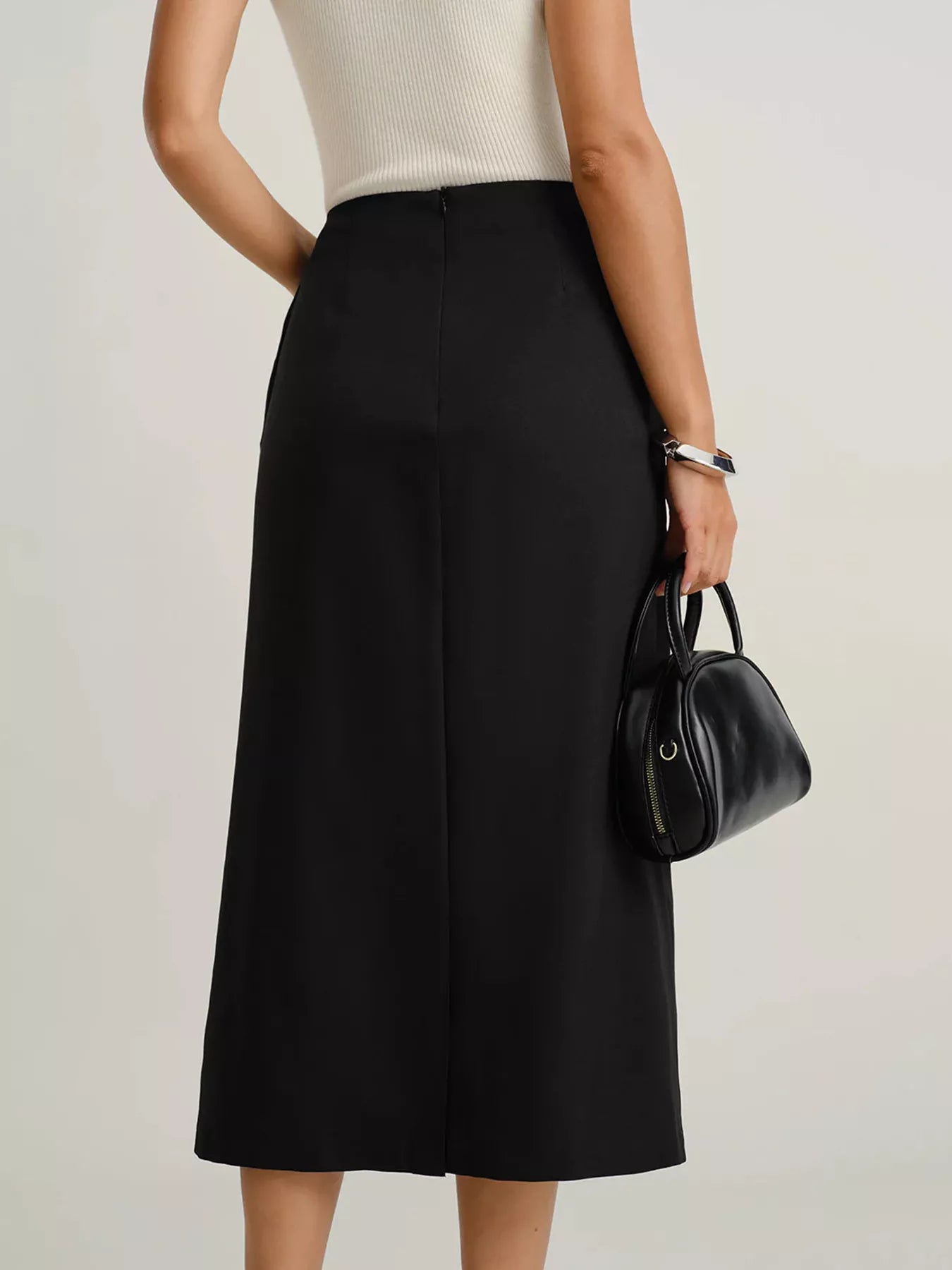 Black midi skirt with pockets and button front, shown from the back.