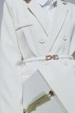 White leather belt with gold geometric buckle, styled with a cream blazer.