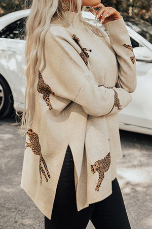 Cream mock neck knit sweater with leopard print details and side slits.