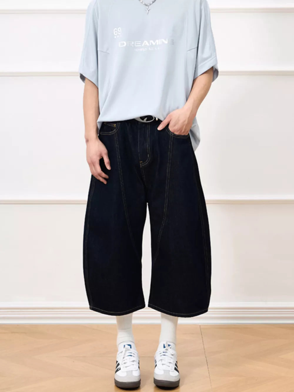Oversized cropped dark navy denim shorts with balloon cut and visible stitching.