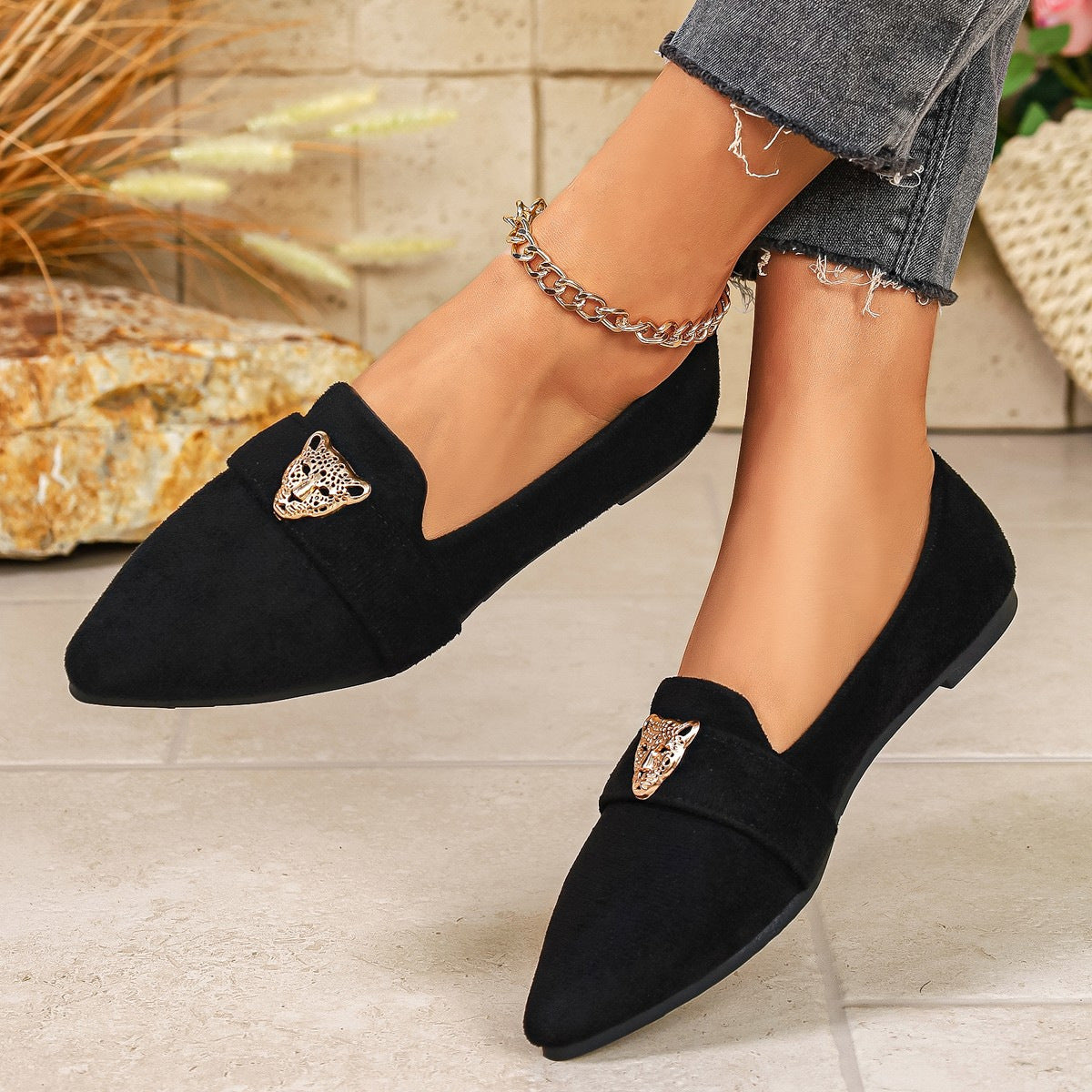 Black slip-on flats with pointed toe and leopard head embellishment