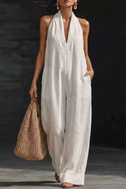 White halter-neck pocketed jumpsuit with wide legs and a deep V-neckline.