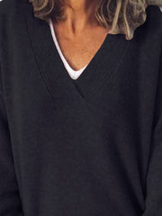 Black ribbed knit sweater with a deep V-neck, layered over a white tank top.