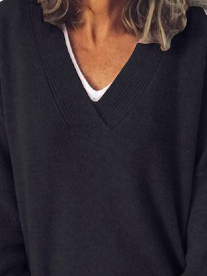 Black ribbed knit sweater with a deep V-neck, layered over a white tank top.