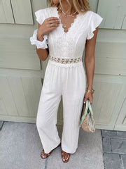 White lace-trimmed wide-leg romper with flutter sleeves and cutout waist detail.
