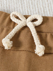 Khaki cotton baby set detail with a cream braided drawstring and frayed ends.