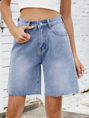 Longline denim shorts in medium wash with a raw hem and relaxed fit.