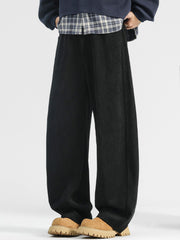 Men's black loose fit sweatpants with pockets and a textured fabric.