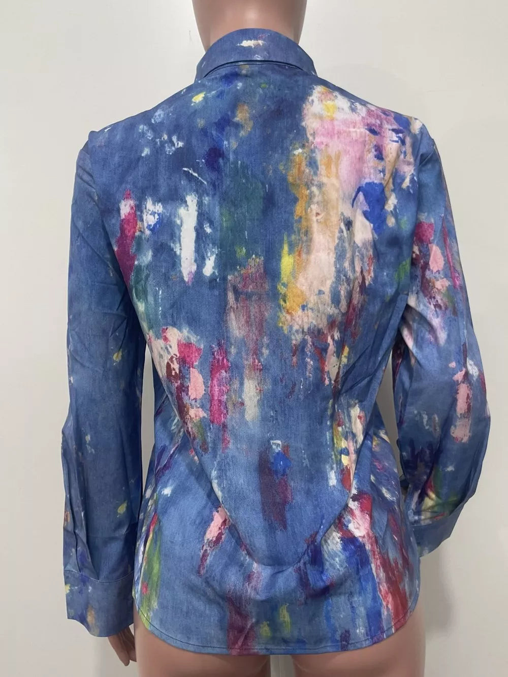 Denim button-up shirt with vibrant abstract paint splatter pattern, long sleeves, and collar.