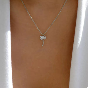 Silver palm tree pendant necklace with crystal accents on a delicate chain.