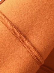 Orange casual zip-up top and wide-leg pants set detail showing textured stitching on soft fabric.
