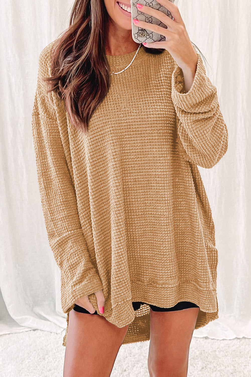 Tan waffle knit oversized top with slit hem and long sleeves.