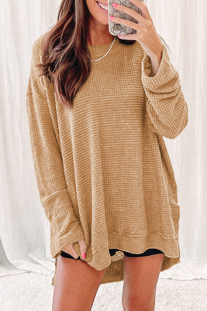Tan waffle knit oversized top with slit hem and long sleeves.