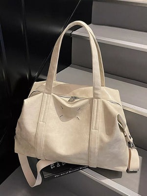 Cream white distressed vintage leather travel bag with top handles and zipper closure.