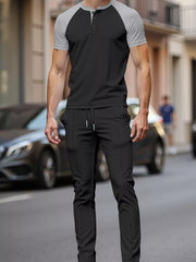 Men's black and grey loungewear set with drawstring pants and a henley t-shirt.