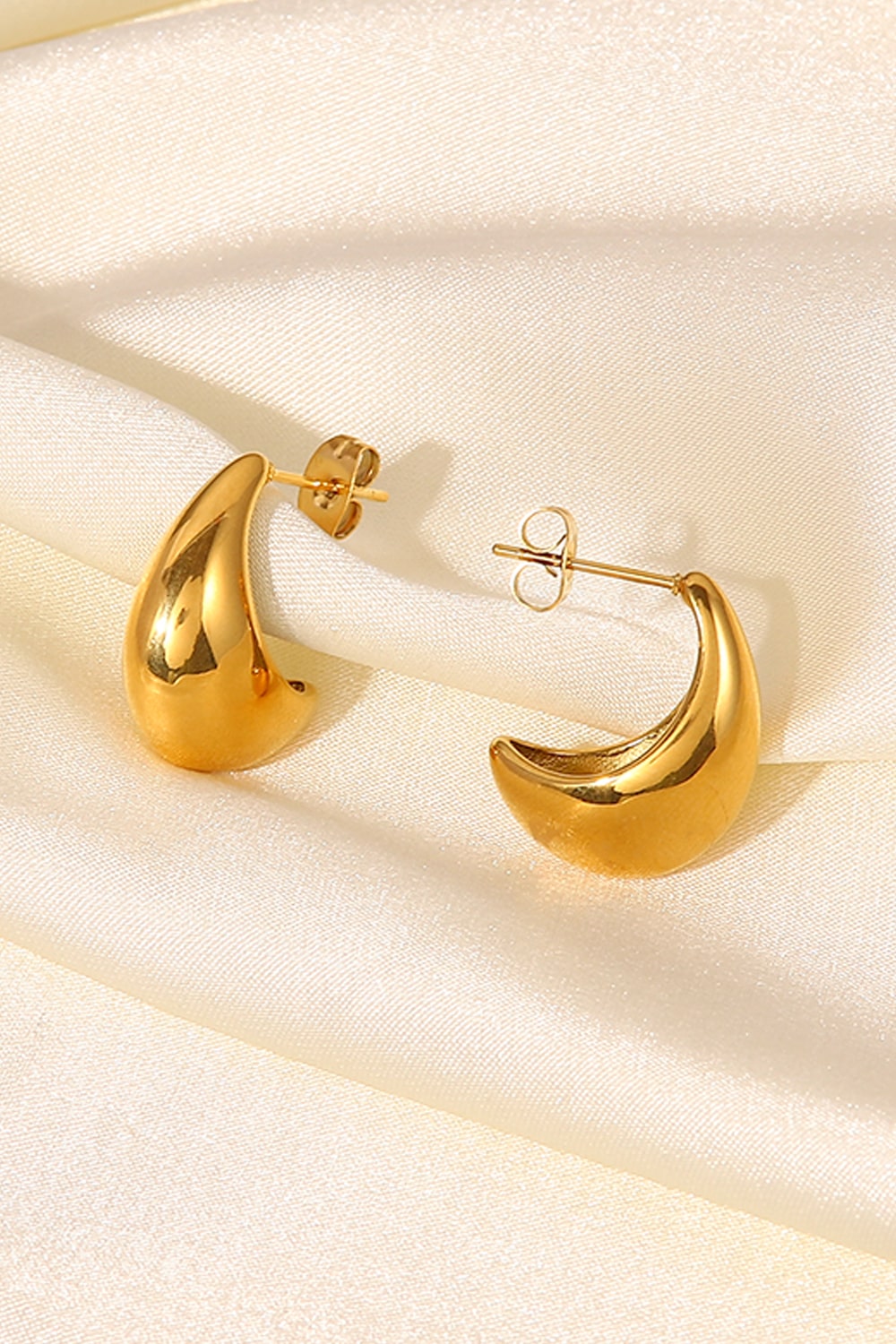 Gold sculpted crescent hoop earrings with post backs.