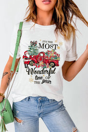 White graphic tee with Santa, Christmas tree, and red truck loaded with gifts.