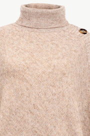 Tan knit poncho with turtleneck and button detail on shoulder