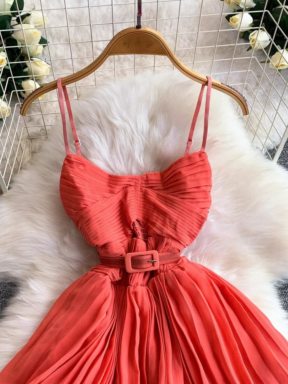 Coral belted pleated midi dress with spaghetti straps and square buckle.