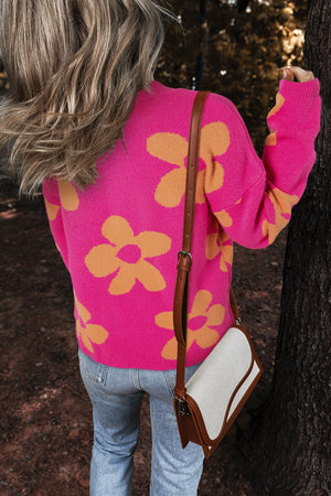 Cerise oversized knit sweater with large orange floral print, crew neck, long sleeves.
