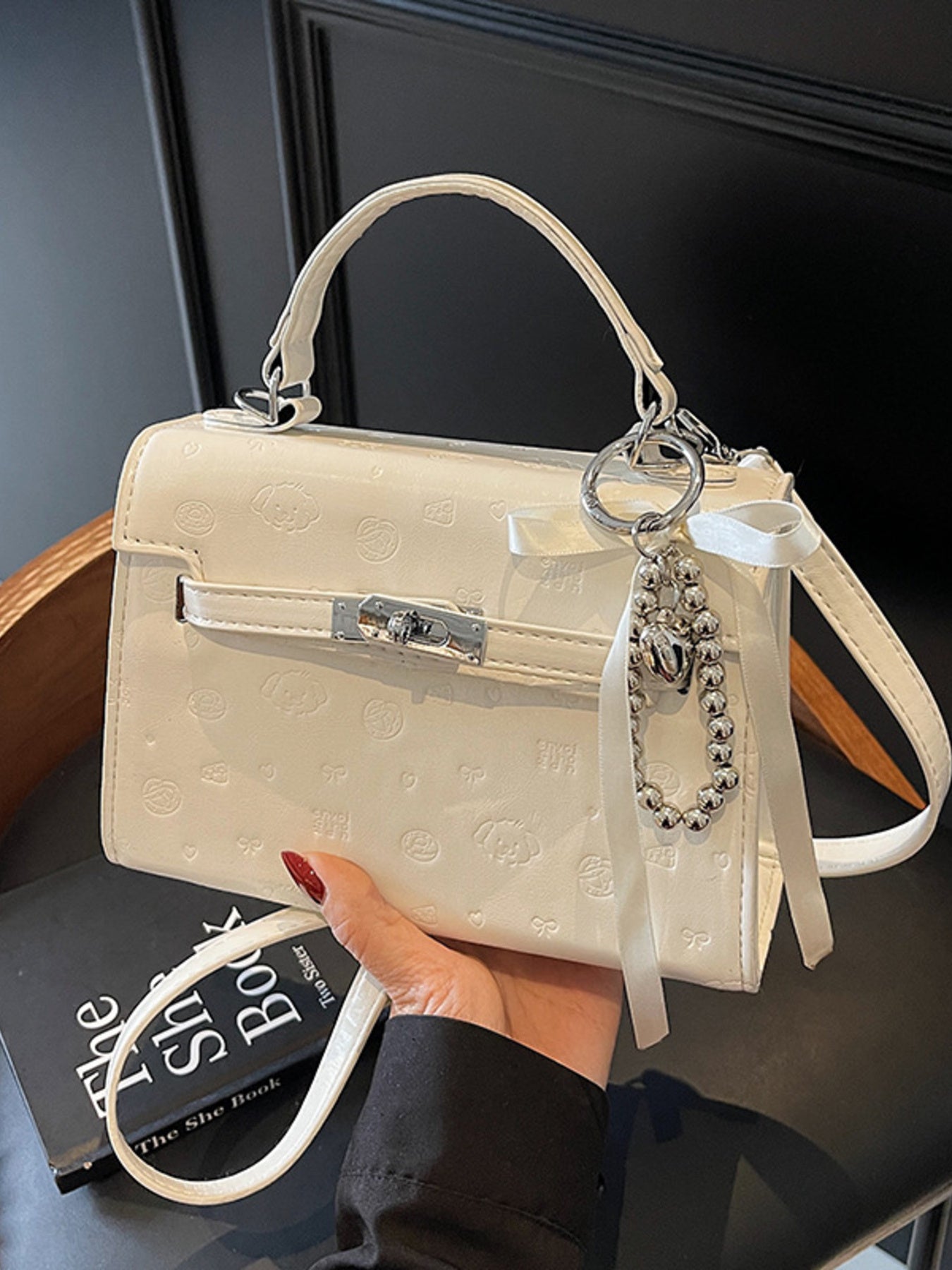 Ivory embossed pu leather mini crossbody bag with dog and heart pattern and charm.